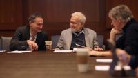 3 men discussing around a conference table